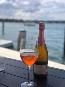 悉尼Newly Reburbished Sydney Harbourfront Boathouse Escape的玻璃杯旁的一瓶葡萄酒