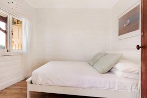 悉尼Newly Reburbished Sydney Harbourfront Boathouse Escape的白色的客房设有一张带窗户的床