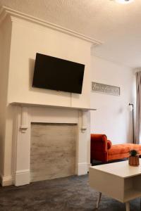 BeestonCharming 3 Bedroom Property FREE WiFi & Parking的客厅设有壁炉上方的平面电视