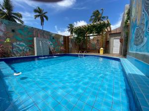 圣米格尔-杜斯米拉格里斯Chalé Palhano Beach的一座建筑一侧带壁画的大型游泳池
