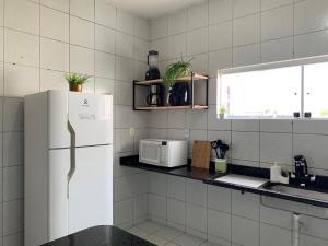 纳塔尔Casa 3 suítes com piscina的厨房配有白色冰箱和窗户。