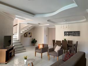 纳塔尔Casa 3 suítes com piscina的客厅配有沙发、椅子和电视
