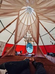 奥克萨潘帕Biosfera Lodge tipi para 3 personas的躺在帐篷里的床上的人