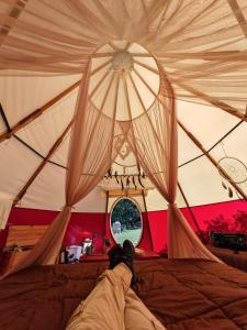 奥克萨潘帕Biosfera Lodge tipi para 3 personas的躺在帐篷里的床上的人