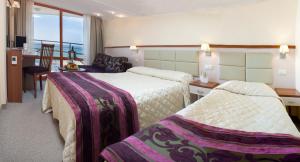 阿尔贝纳Kaliakra Beach Hotel - Ultra All Inclusive的酒店客房配有两张床和一张书桌