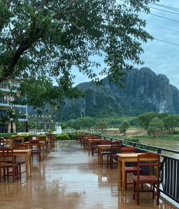 万荣Lisha The Grand Riverside Hotel的雨中一排桌椅