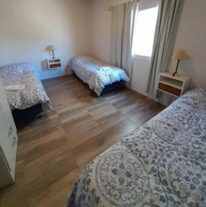 圣拉斐尔Finca La Calma的一间卧室设有两张床,铺有木地板