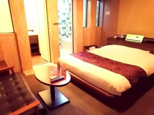 东京HOTEL WILL渋谷 LOVE HOTEL -Adult only-的酒店客房配有一张床铺和一张桌子。