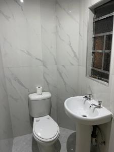 索韦托Eldos Guest House的白色的浴室设有卫生间和水槽。