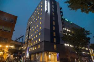 北九州Quintessa Hotel Kokura Comic & Books的上面有灯号的高楼