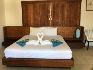 班邦宝宾泊普村庄酒店的一间卧室配有一张床,上面有两条毛巾
