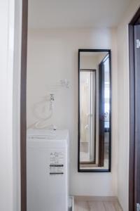 大阪桜の宿的一间带镜子和白色冰箱的浴室