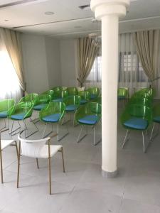 科托努Hotel Bel Azur Cotonou的一间设有绿色椅子和柱子的房间