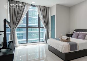 八打灵再也Atria Sofo Suites - Petaling Jaya的一间卧室设有一张床和一个大窗户