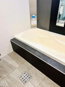Kami-seyaAsokono Hotel的带浴缸的浴室和排水管