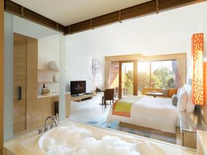 迈考海滩普吉万丽度假酒店的一间卧室配有一张特大号床和一个浴缸