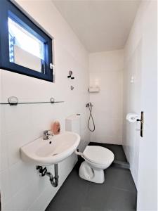 特孔Villa Robinson的白色的浴室设有水槽和卫生间。