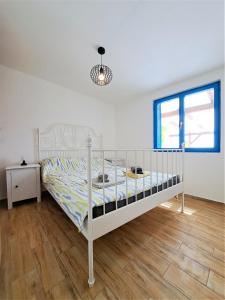 特孔Villa Robinson的卧室铺有木地板,配有一张白色的床。