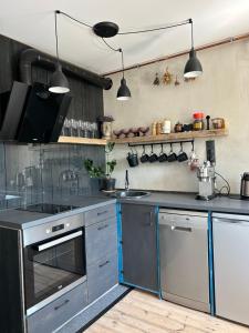 利耶帕亚Mareena_apartments的厨房配有不锈钢用具和黑色柜台