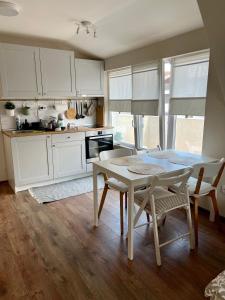 布尔加斯Dockview atelier的厨房配有白色橱柜和桌椅