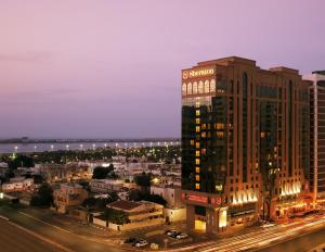 阿布扎比Sheraton Khalidiya Hotel的一座高大的建筑,旁边有一个标志