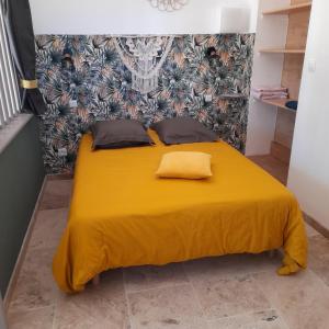 博迪昂Villa Castellane的一张黄色的床,上面有两个枕头