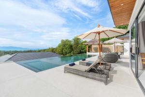 苏梅岛Beautiful 4 Bedroom Luxury Villa with Sea Views- KBR2的一个带遮阳伞和椅子的户外庭院和一个游泳池