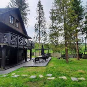伊斯泰布纳Fabryka Snów loft w sercu Beskidów的房屋设有带桌子和长凳的庭院