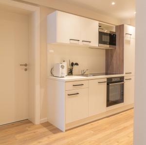 HainfeldMM-Apartments Hainfeld的厨房配有白色橱柜和水槽
