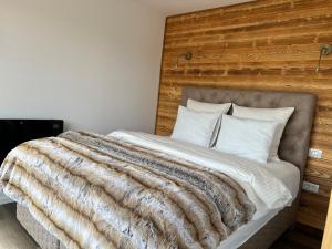 陶比斯特拉Heaven`s cabins的一间卧室配有一张大床和木制床头板