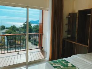 纳闽巴霍科莫多西尔维亚酒店及度假酒店的一间卧室,享有带一张床的阳台的景色
