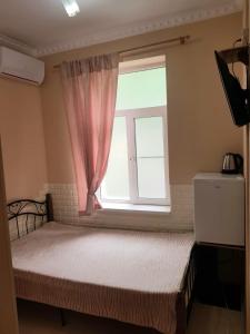 加格拉Guest House Gorny Ruchei的一间卧室配有一张带粉红色窗户的床