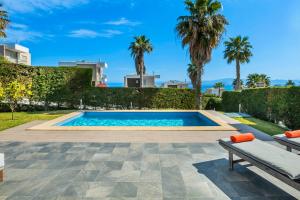 佩科霍里Aegean Sea View Villa的棕榈树庭院内的游泳池