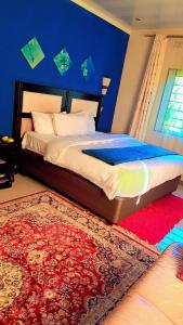 利文斯顿Royal Olympia Lodges and Safaris Livingstone的一间卧室配有一张大床和红色地毯。