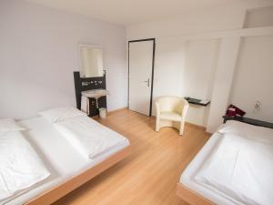 苏黎世格雷戈里酒店的一间卧室配有两张床和椅子