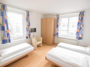 苏黎世格雷戈里酒店的一间卧室设有两张床和两个窗户。