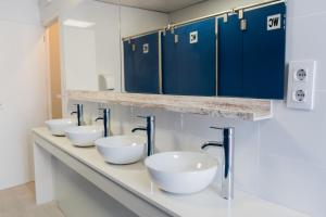贝尼卡西姆HOSTEL PRIME的蓝色橱柜浴室里的一排水槽