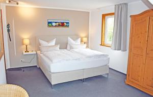 洛默Hotel Inselglück的窗户客房内的一张大白色床