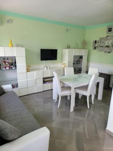 诺托玛丽娜Casa Falconara的一间设有白色桌子和白色椅子的用餐室