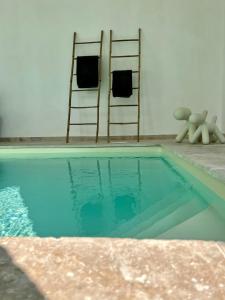IsquesManoir Les Feuillantines Piscine & Spa的一个带两把椅子和毛巾架的游泳池