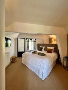 IsquesManoir Les Feuillantines Piscine & Spa的卧室设有一张白色大床和一扇窗户。