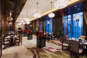 当涂马鞍山万达嘉华酒店的用餐室配有桌椅和吊灯。