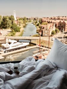 格但斯克Holiday Inn Gdansk - City Centre, an IHG Hotel的一张带咖啡的床铺,享有河景