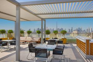 迪拜Element Al Jaddaf, Dubai的一个带桌椅的庭院,享有城市美景。
