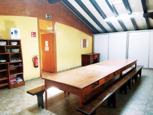 Maya del BaztánAmaiurko Aterpea的配有长凳的房间里一张大木桌