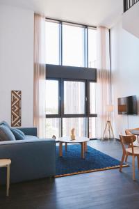 孔恩斯灵比The Forest apartments by Daniel&Jacob's的客厅配有蓝色的沙发和桌子