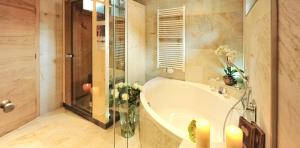 伊施格尔Salnerhof Superior Lifestyle Resort的带浴缸和花瓶的浴室