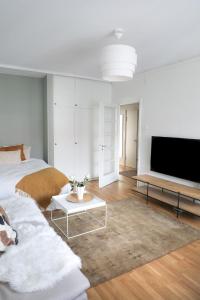 图尔库Studio-Joki - Valoisa asunto keskustassa的一间带两张床和电视的客厅