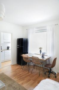 图尔库Studio-Joki - Valoisa asunto keskustassa的用餐室配有桌椅和黑冰箱。