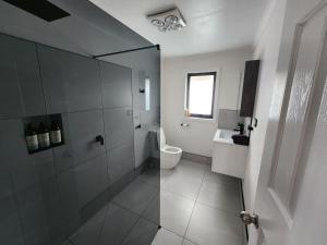 斯特拉恩Bayviews的白色的浴室设有卫生间和水槽。